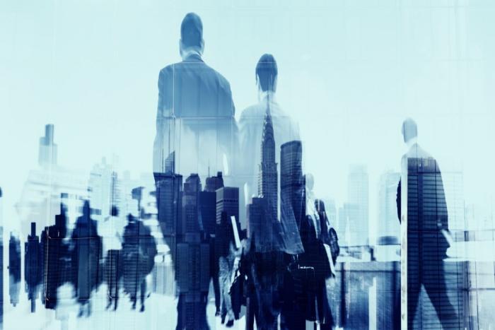 Corporate Cyber Risk Issues Image of business commuters in front of a city skyline