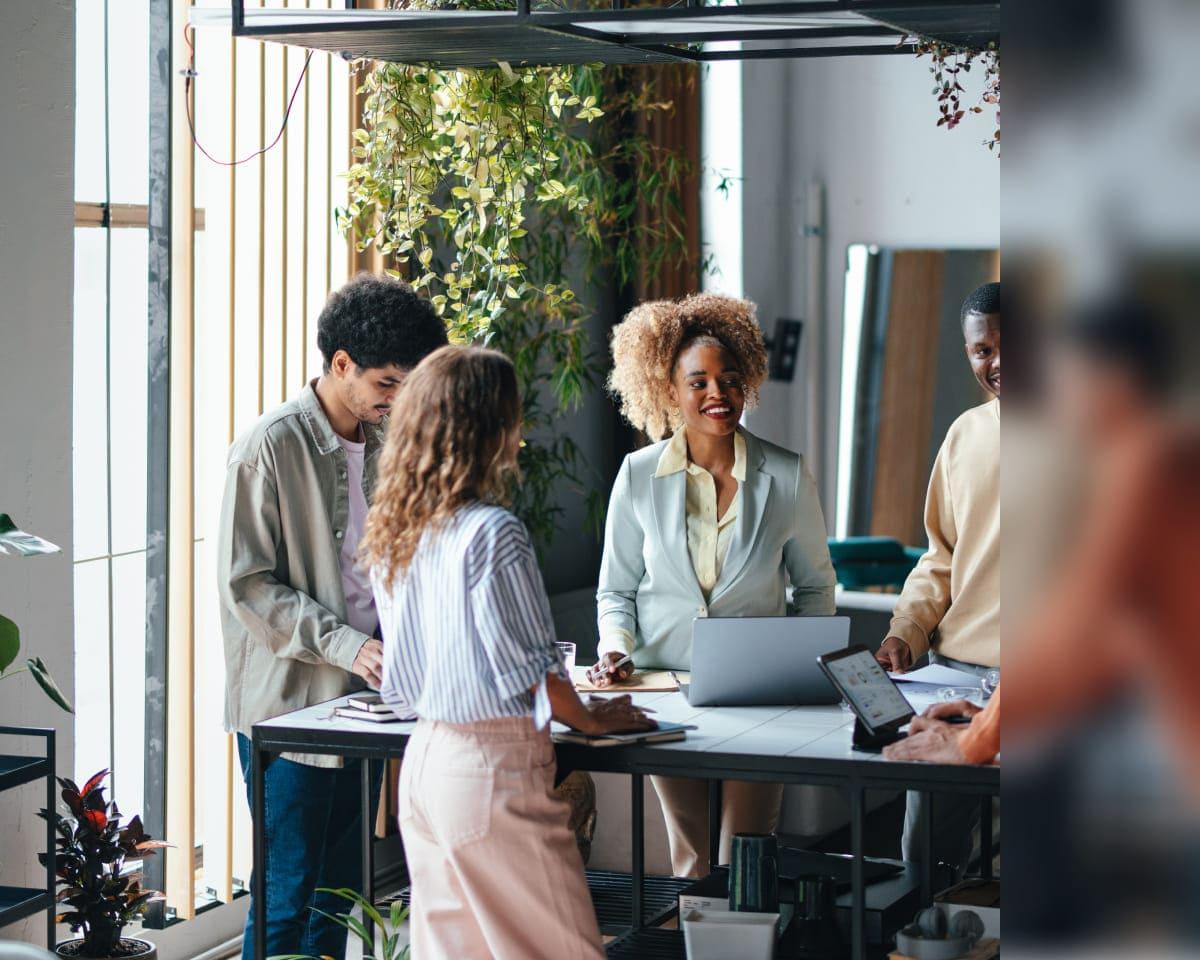 A team of individuals engaged in discussion around a table with laptops, showcasing Zscaler's commitment to collaboration and progress.