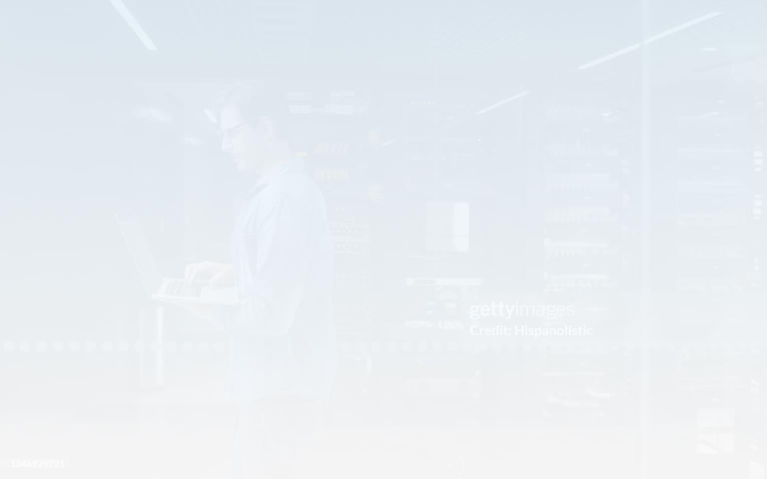 A man stands with laptop, focused on topics of artificial intelligence and cybersecurity.