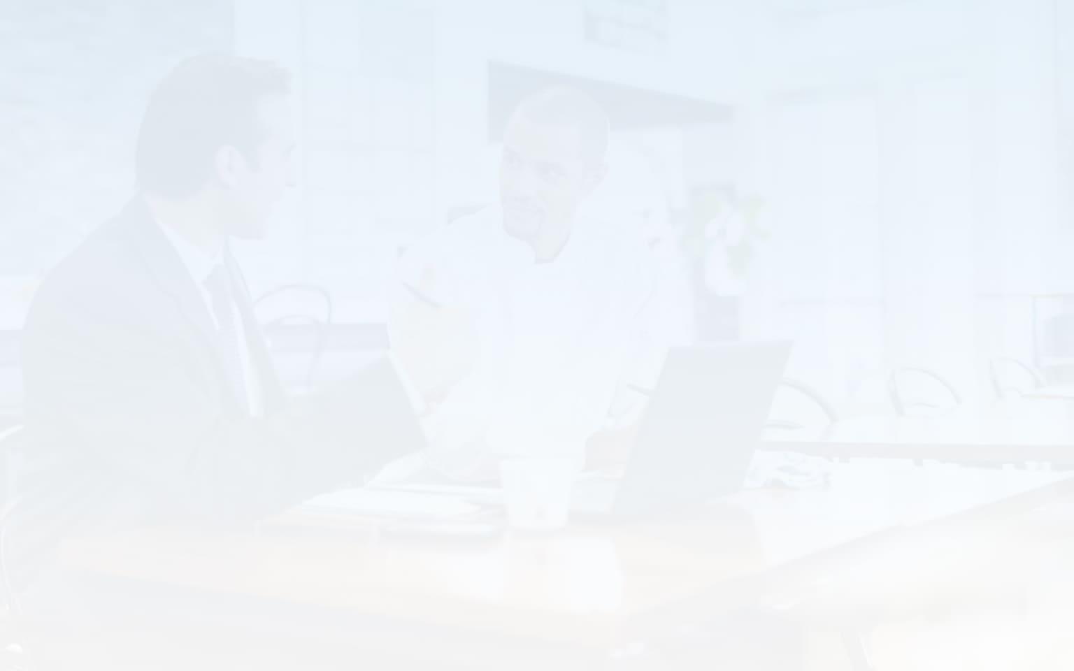 Two men sitting at a laptop discussing data security posture management