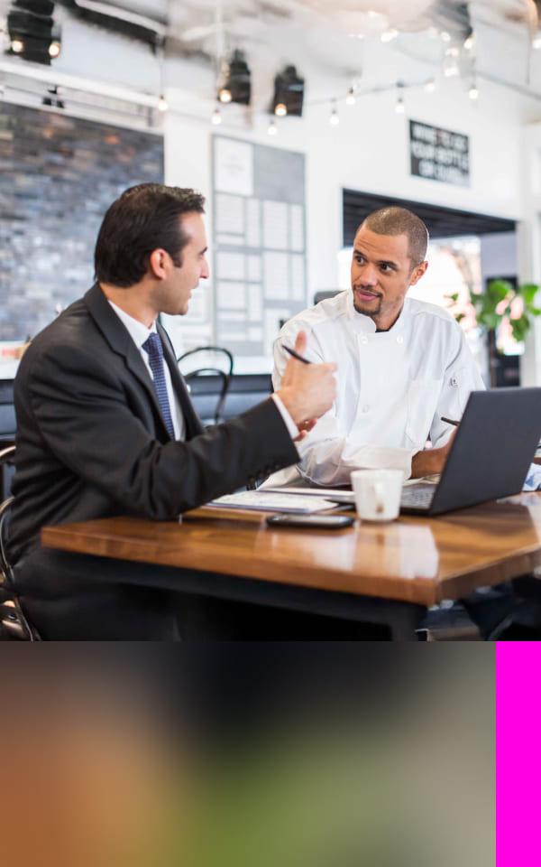 Two men sitting at a laptop discussing data security posture management
