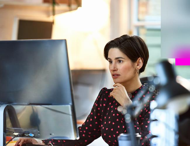 A woman sitting at her computer researching what network security is