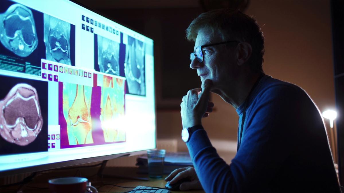 Man looking at medical images on a large screen