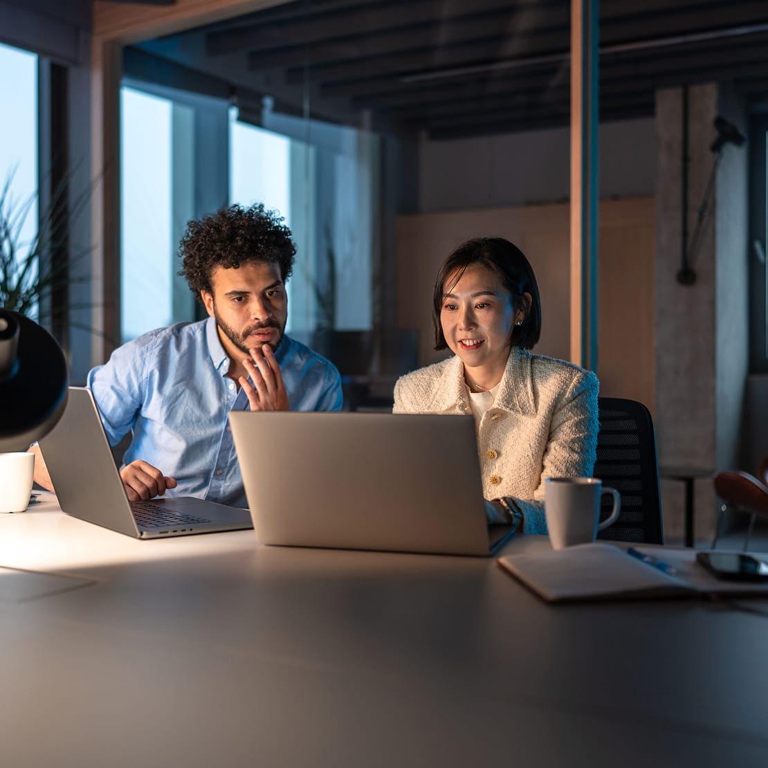 A man and a woman looking at laptop discussing regulations